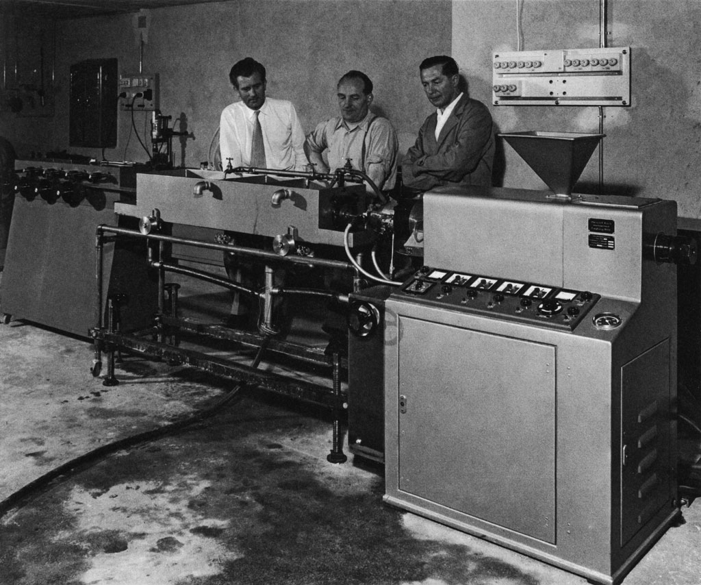 Firmengründer in Garage mit erster Maschine